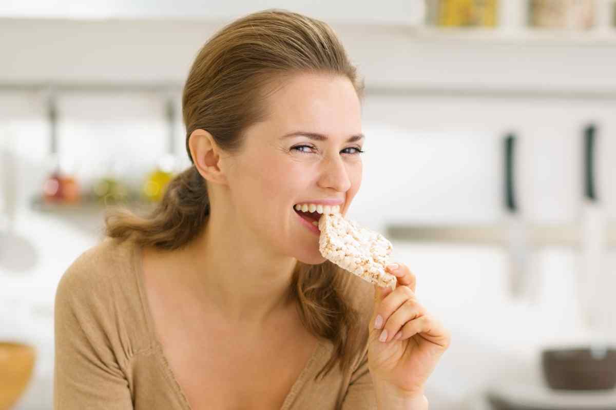 donna mangia cibi croccanti come gallette di riso per dimagrire