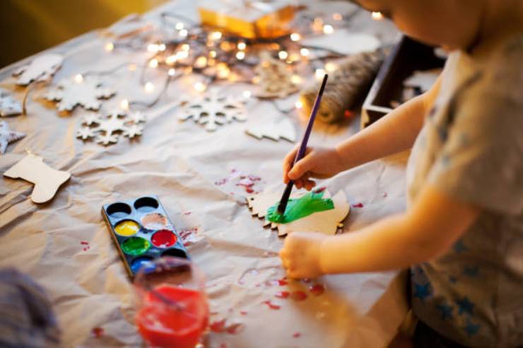 Bambino che realizza decorazioni di Natale