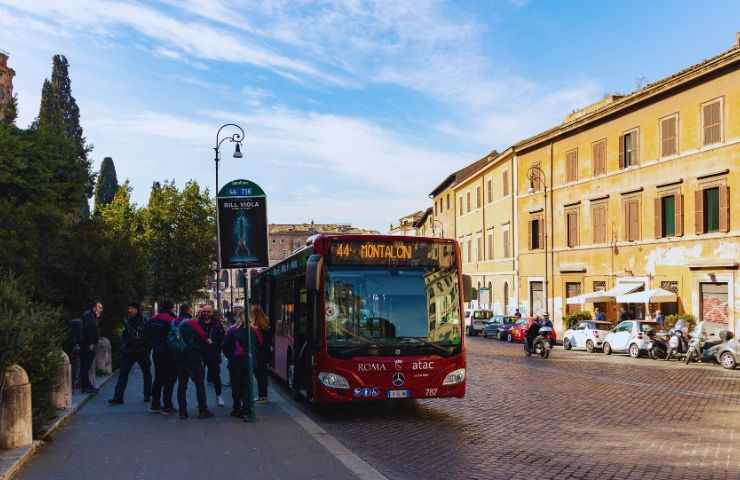 autobus a Roma alla fermata con tante persone ad aspettarlo