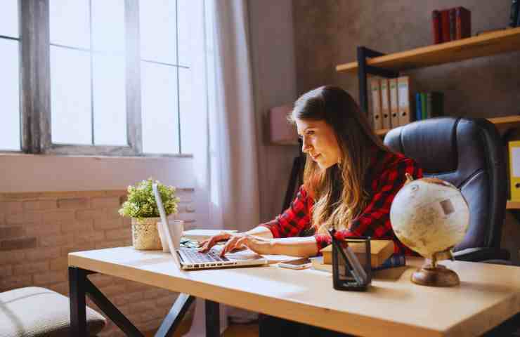 ragazza al computer seduta alla scrivania